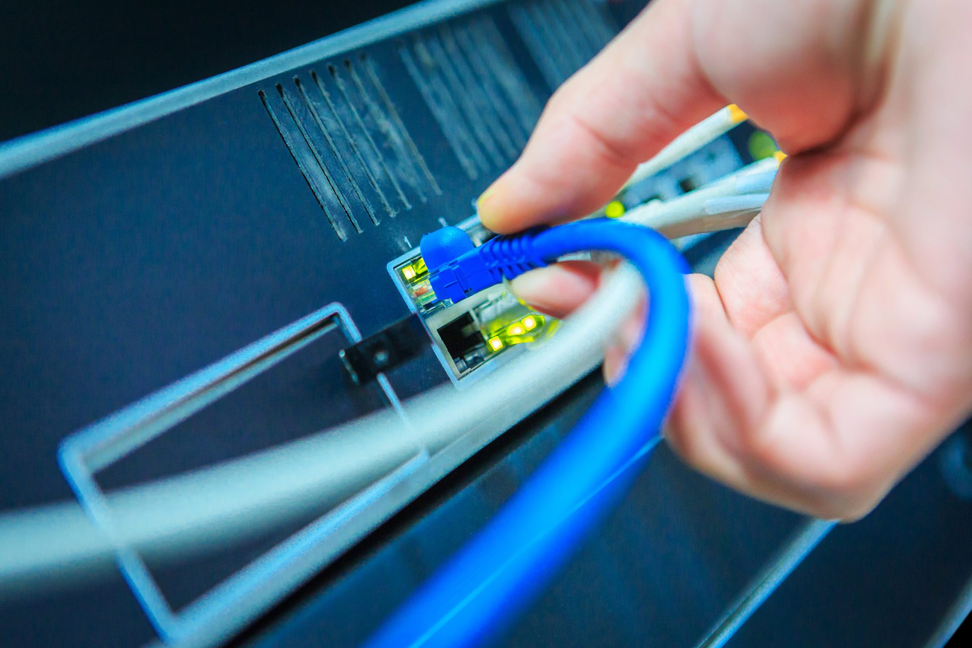 Image of someone plugging a network cable in